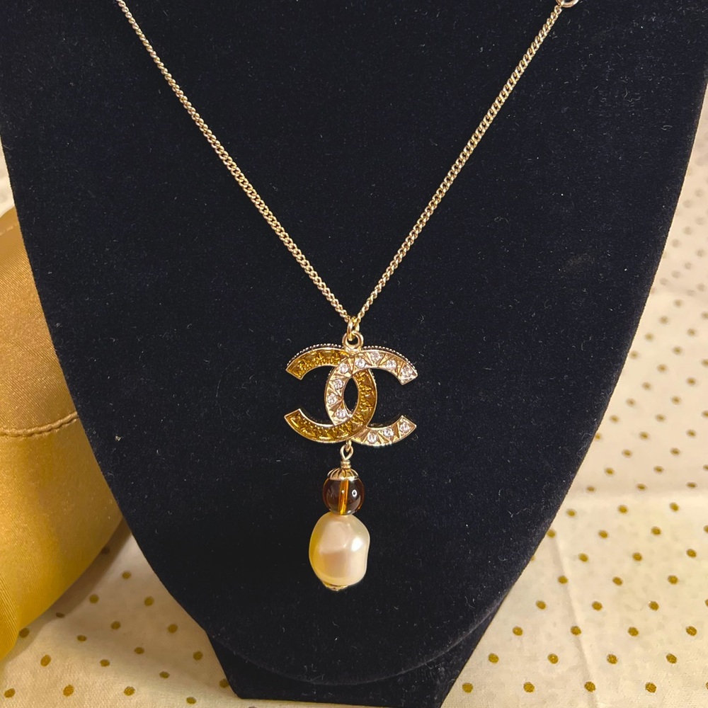 CHANEL “CC” pendant necklace with faux pearl drop.